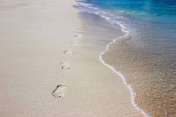 Footprints along soft sea wave