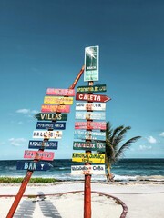 Señal que indica la distancia de distintas ciudades del mundo en una playa del caribe