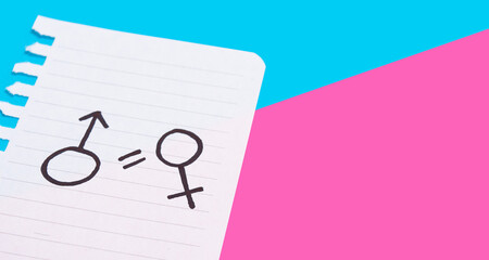 The concept of gender equality. Torn paper with painted female and male symbols on a blue-pink background. Equality of rights of men and women.