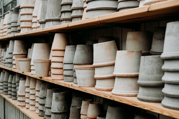 A variety of empty decorative ceramic flower pots in different sizes and shapes for sale on the shelves at the garden center