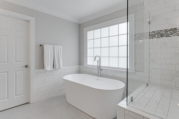 White clean Minimal Modern primary bathroom with jacuzzi tub and stand in walk in shower with large window  
