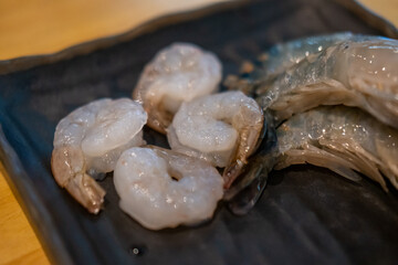 Raw shrimp on plate, food preparation for cooking.