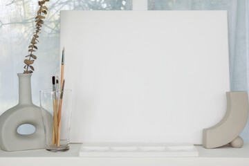 Equipment and canvases for painting were arranged on a table in the living room where the artist imagination could be drawn and the blank white canvas provided space for the artist imagination.