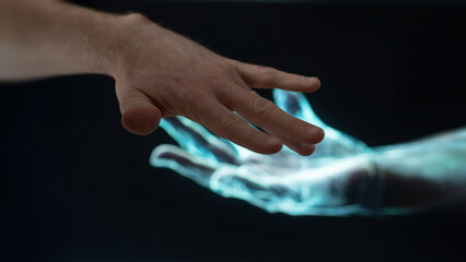 An human man hand laid on a virtual hand. Virtual meeting on a black background.