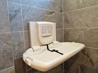 Baby nappy diaper changing table in a public toilet restroom. Child changing board in a public restroom