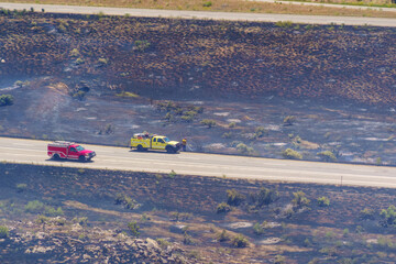 Obraz premium Wildland engine and crew engage in suppression activities on a vegetation fire