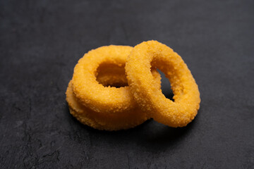 Fried onion rings on black  background