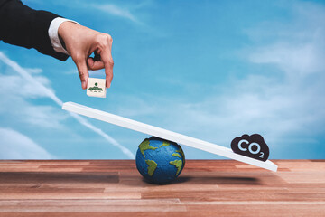 Businessman weigh solar panel icon on scale against a CO2 symbol, promoting zero CO2 emission....