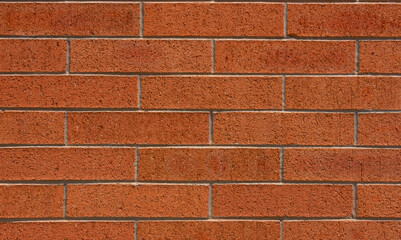 Closeup of red brick wall construction with concrete seams on exterior of old vintage building in sharp focus for backgrounds, patterns and projects. - 618894746