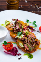 Potato pancakes with beef, Dijon mustard, tomatoes, lettuce and sour cream, fresh dish.