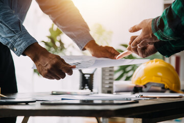 Construction and structure concept of engineer working drawing on blueprint meeting for project working with partner on model building and engineering tools in working site, construction concept.