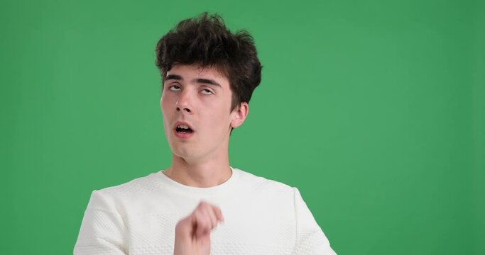 Caucasian man reacts to something falling in his vicinity. Against a vivid green backdrop, his wide-eyed expression and raised hands convey a sense of alarm and astonishment.
