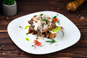 Beef steak with rustic potato wedges, mushrooms, sauce, tomatoes, lettuce and herbs, fresh lunch.