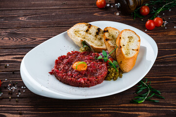 Beef tartare with raw egg, cherry tomatoes, pickles and fried toast.
