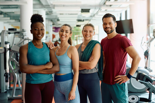 Group of young happy athletes in gym looking at camera.