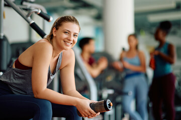 Happy athletic woman during sports training in gym looking at camera.