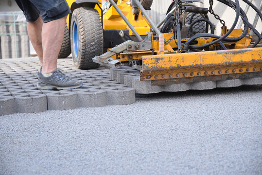 Baumaschine auf Baustelle mit Rasengittersteine