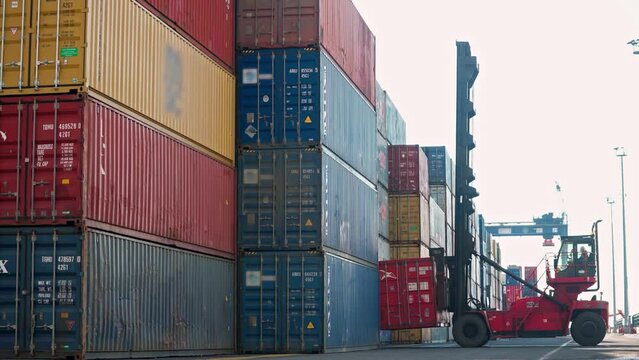 4K footage of forklift bringing down container. Colorful shipping containers stacked at port stock video.
