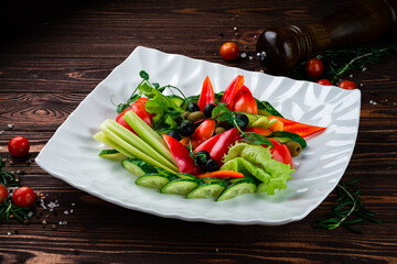 Sliced vegetables: sweet pepper, olives, cucumbers, lettuce, cherry tomatoes, celery and greens.