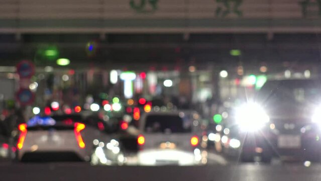SHIBUYA, TOKYO, JAPAN - JUNE 2023 : View of Shibuya crossing at night. Car passing by on the road. Street traffic, vehicle and transportation concept 4K video.