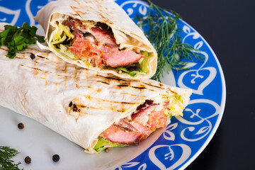 Delicious kebab with meat, lettuce, tomato, onion and sauce with french fries.