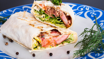 Delicious kebab with meat, lettuce, tomato, onion and sauce with french fries.