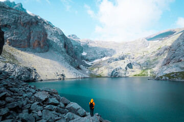 Back shot of an adventurer by glacier lake