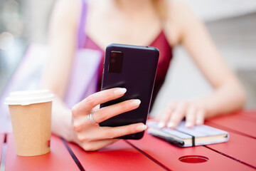 Young woman looking at her schedule and using her cell phone