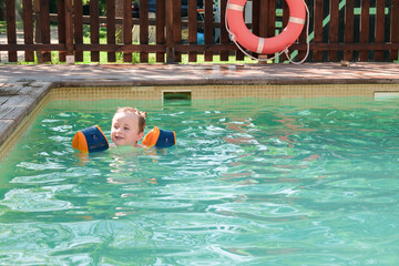 Playing sibling in swimming pool in summer day