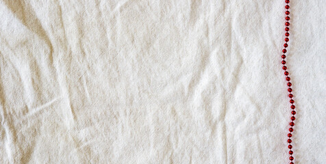 Red line beads on the light linen fabric background