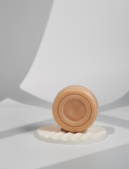 Bar of round soap, isolated on white stand, individuality concept