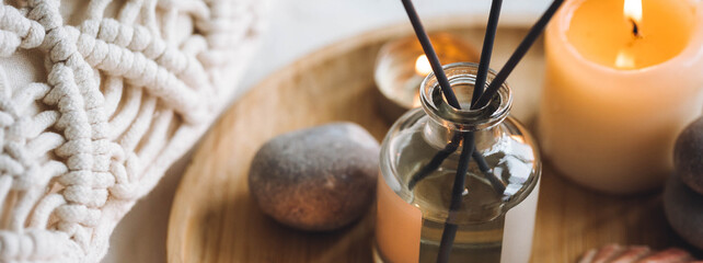 Cozy corner for home meditation and relaxation. Aroma diffuser, burning candles, stones for comfort, pleasure, aromatherapy. Decor for apartment, house, indoors design. Banner