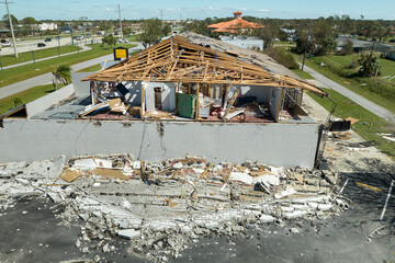 Consequences of natural disaster. Damaged house roof with missing shingles and broken apart walls after hurricane Ian in Florida