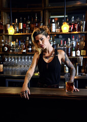  Young woman working as a bartender, some tattoos, looks a bit cheeky. Blurred alcoholic beverages background. Generative AI