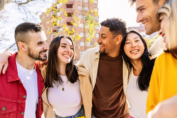 Young student friends group smile standing together outdoors. Diverse college people having fun enjoying funny moments in city street. Youth community and friendship concept.