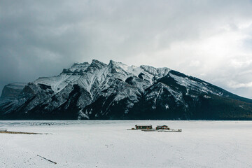 Frozen Lake Minnewanka, with a snow covered mountain behind