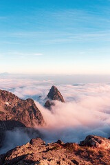 Mountain peaks above clouds during sunset