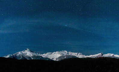 Night sky over a snow covered mountains
