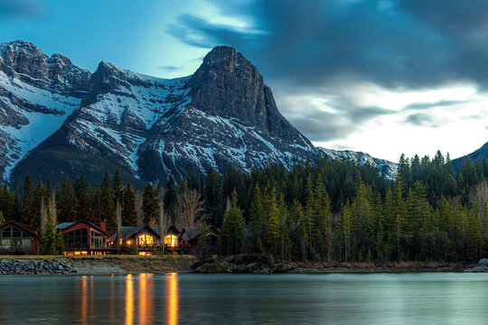 Wooden cabins in forest below mountain peak during night