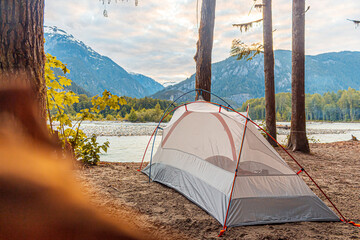 Camping in a tent next to a river and mountains © Martin
