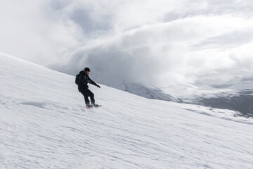 Snowboarder going down a ski slope