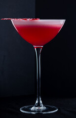 Strawberry daiquiri made with white rum, strawberry syrup and lime juice on a dark background.