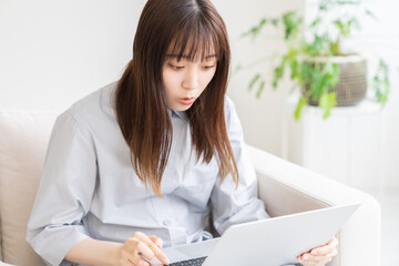 部屋でラップトップコンピューターを見る女性