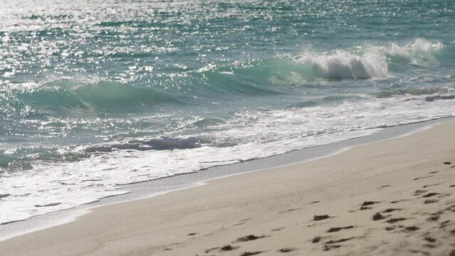 Slow motion clear blue waves with strong wind on a sandy empty beach in Cannes in spring