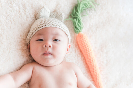 フォトスタジオで撮影されたウサギの帽子をかぶった赤ちゃん
