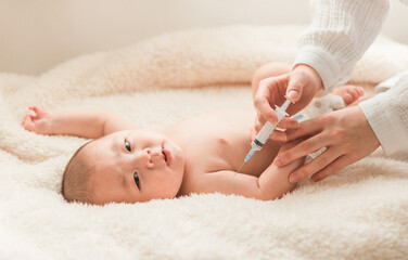 予防接種・ワクチンの注射を打つ医者と乳児赤ちゃん
