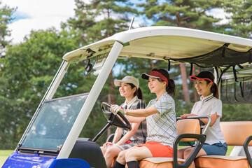 ゴルフ場でゴルフカートに乗るゴルファーの女性（ゴルフ女子）
