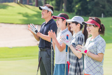 ゴルフ場でゴルフを楽しむゴルファーの男女
