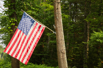 US flag waves proudly in front of an American home, representing the meaning and symbolism of...
