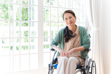 家で車椅子に乗っているシニア女性（介護・福祉）